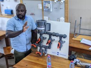 Mawuli Tsikata, Assistant Manager, Technical Services at Safe Water Network, explains to participants how a chlorinator works