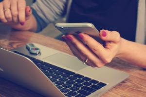 CarGuard helps protect online purchasers like this woman using her iPhone and laptop