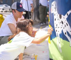 A young volunteer adds the spots to the Dalmatian.