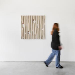 Woman walks past "Angel's Secret 1" artwork hanging on wall