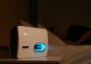 Lifestyle photo of the HaloOne® Halotherapy Generator delivering on-demand salt therapy to a consumer within their existing Clearlight® Sauna.