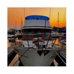 Image shows The Procecco, Passione Brands' Meet "The Prosecco"—Passione Brands' 38' motor yacht anchored in the Berkeley Marina during sunset on the water.  The yacht is an extension of the Passione Emporio.