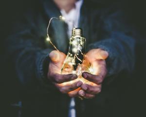 A man holds a lightbulb in his hands, representing Darren and Mike’s bright future with Enagic