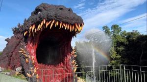 Splashing water in front of giant Godzilla zipline statue