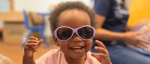 young black girl smiling wearing sunglasses