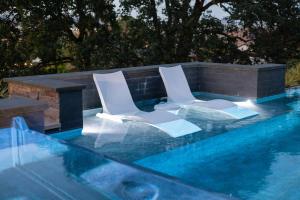 chairs sitting on the baja shelves in the beautifully blue pool with an infinity edge