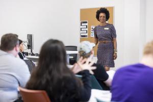 ACC professor with students learning and listening at desks