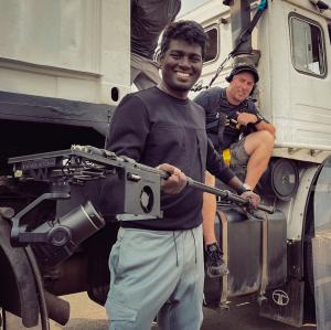 Director Atlee Kumar holding WarpCam®, with Ferdi Fischer leaning against a truck in the background.