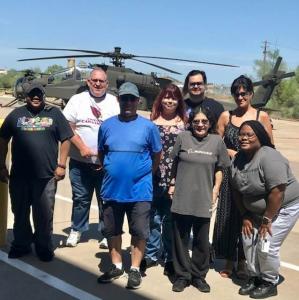 team from the first Fulfillment Center in front of an Apache Helicopter.