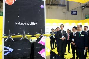 At the 1st World Climate Industry Expo (WCE) on May 27, Kakao Mobility CEO Ryu Geung-seon (center) and Vice President Jang Seong-wook (left) explain UAM aircraft to Prime Minister Han Deok-soo (right) who visited the booth.  (Photo - Kakao Mobility)