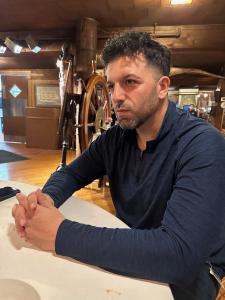 Rich Castaldo sitting at table speaking with guests