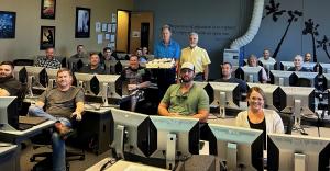 Mainsaver customers in CMMS training class with cake celebrating the company's 40th anniversary