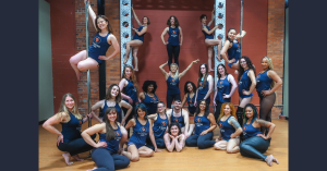 Owners and Instructors Posing in New Watertown Studio On Floor Sitting on Dance Poles Climbing Truss and Performing Acrobatics