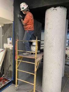 Workman applies terrazzo by hand to a column.