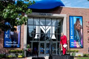 Mercy University President Susan L. Parish unveils new signage in front of Main Hall in Dobbs Ferry.