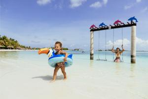  A little girl is playing in the water with a Family Holiday swing from Cinnamon Hotels & Resorts.