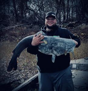 This image features Austin Pettigrew, Owner of Take Down Rod Holders, holding a giant catfish