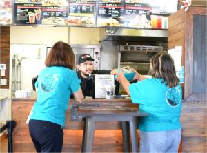 Virginia hands copies of the booklet to a local take-out so they can provide them to customers.