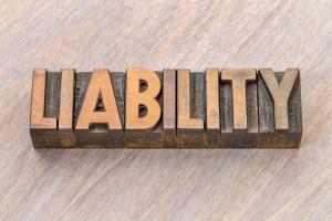 A wooden carveout of the words LIABILITY