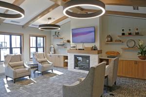 Custom furniture in a casual setting with views and a fireplace provides space to socialize.  Designed by the Senior Living Design Studio of Plunkett Raysiich Architects, LLP