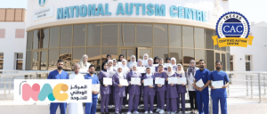 ONAC team standing in group photo in front of center with logo and CAC badge