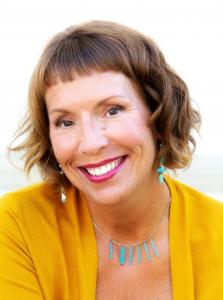 Dr. Nasha Winters smiling, wearing a yellow cardigan and turquoise