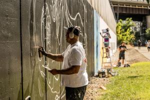 Artists painting mural during NoMa in Color mural festival