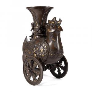 Chinese 18th century style bronze and parcel "Phoenix Bearing Zun" wine vessel on wheels, the tall Gu form vessel with trumpet form rim resting in a hole at the center of the bird's back ($51,425).