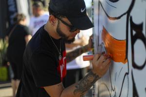 An artist draws with a marker on a white board