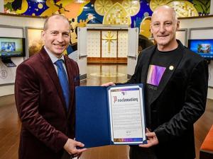 At the Church of Scientology Harlem Community Center, Peace Lights Founder (right) presents a representative of the Church with a proclamation thanking Founder L. Ron Hubbard for the Church’s Human Rights educational initiatives.