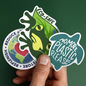 Image of a hand holding three eco-safe sticker collection.