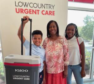 Family with student in front of Lowcountry Urgent Care sign