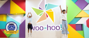 two boys jumping in the air in front of woo-hoo! sign