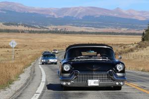 Vintage cars and trucks cruising down the highway