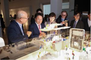 Mayor Kang Ki-jung, Director Song Jin-hee of GIDP, and other dignitaries observed the exhibition artworks. The main artwork in this photo is Lego-like figures in the miniature city, including a swimming pool supported by pillars | Photo - AVING News