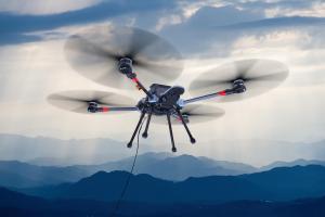 Sentinel tethered drone flying in blue mountains landscape