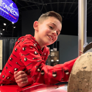 boy exploring hands on exhibit at miSci smiling as he interacts with tactile object