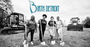 Birth Detroit Co-founders with one foot each on a shovel at building site of the birth center, with construction equipment to the left.