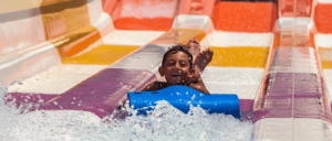 boy on mat sliding down water slide at Big Kahunas