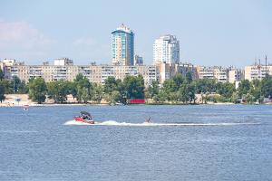 Ski boat in water with city in the background