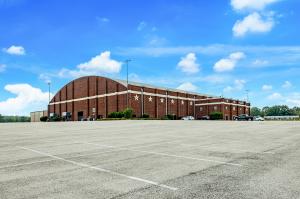 Image shows a large red brick concert hall and expansive parking lot