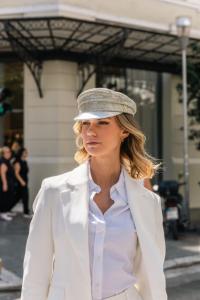 Stylish businesswoman in a white suit wearing a sparkling silver hat with our cutting-edge EEG sensors.