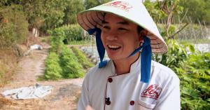 Close-up of Vietnamese man dressed in chef attire speaking at a farm.