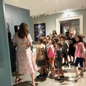 group of children exploring the exhibits with teacher