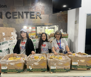 3 female LATLC volunteers working with MEND at the Food Distribution Center