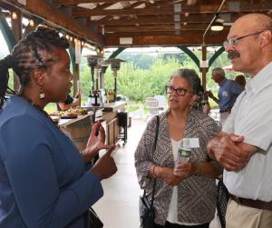 A Community Foundation employee speaks with two people at an event