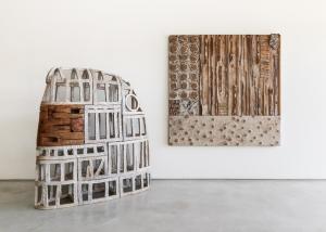 Large mixed media artwork on wall next to a large mixed media sculpture