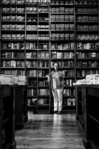 black and white photo of woman in front of book shelves