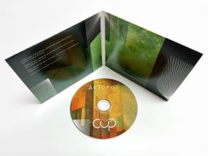 Open album package with CD lying in front, all in rich colors.