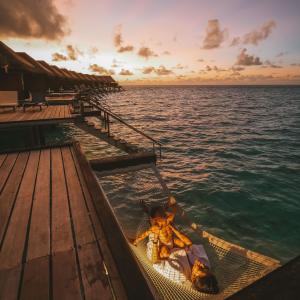 Mother playing with child in a water bungalow in Cinnamon Velifushi Maldives